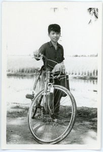 Boy with bicycle in countryside
