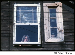 Woman looking out a weathered window in the eaves, Tree Frog Farm Commune