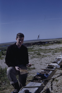 Joel M. Halpern inspecting artifacts.