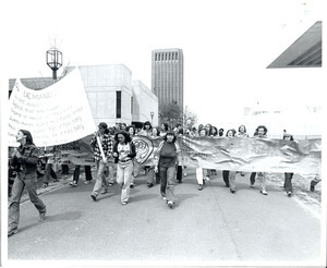 Board of Trustees fee increase demonstration: protestors holding sign and banner, marching from the Student Union to the Whitmore Administration Building