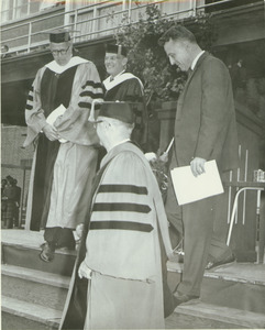 Prof. William H. Ross descends from stage with Provost Gilbert Woodside and Presidents Mendenhall and Gettell after the Centennial Convocation
