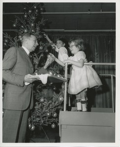 Mr. Burrows helping children decorate Christmas tree