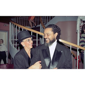 Couple in formal wear smile at each other.