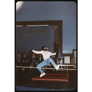 A girl jumps in the air over a rope at the Charlestown gymnasium