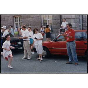 A girl runs and is cheered on by spectators during the Bunker Hill Road Race