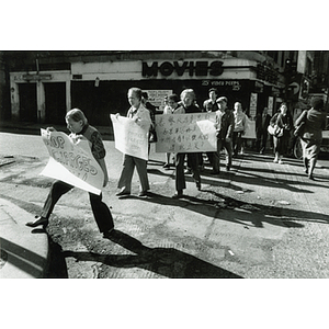 Chinese people marching through Chinatown carrying signs in a community outrage over Long Guang Huang