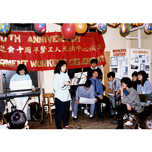 During the Chinese Progressive Association's tenth anniversary celebration, a woman prepares to sing