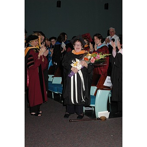 Faculty member poses with flowers at School of Nursing convocation