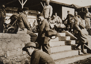 Soldiers sitting on front steps of a canteen