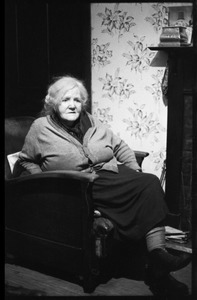 Portrait of an older woman, seated in club chair in a Scottish pub