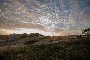 Dune shacks under a dramatic cloudy sky, Provincetown