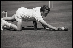 Croquet player sprawling on the ground to line up a shot, Newport, R.I.