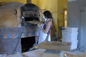 Hungry Ghost Bread: owner and baker Cheryl Maffei putting cookies into the oven