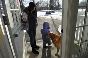 Mother and child leaving the New Salem Public Library, greeted by a waiting golden retriever