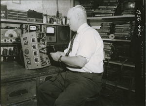 Donald Curtis sitting at a workbench, working on equipment