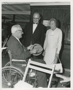 Man in wheelchair talks to couple