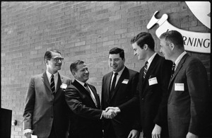 Governor Volpe and Elliot Richardson at Boston University: Richardson on stage with Volpe, who greets three other men
