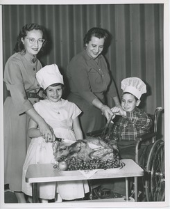 Unidentified women carving turkey with young clients