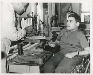 Unidentified man demonstrating bandsaw for Luis Damilano