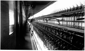 Spinning frame in the spinning room of a textile mill. [01]