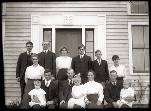 Family (?) seated by front door of a house (Greenwich, Mass.?)