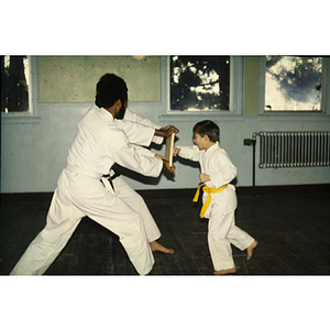 Students in a martial arts class practicing with a wooden block