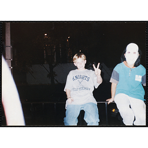 A boy making a V-sign, another wears a white mask during a Boys & Girls Club event