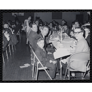 Men and boys pose for a shot at a table during a Dad's Club/Mother's Club banquet
