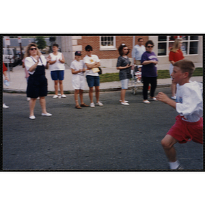 A boy runs past spectators during the Bunker Hill Road Race