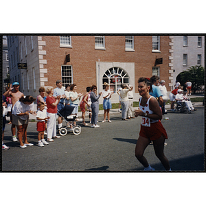 A runner passes cheering spectators during the Bunker Hill Road Race