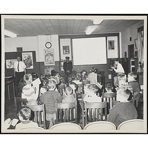 A fireman leads boys in a fire prevention seminar at the South Boston Clubhouse