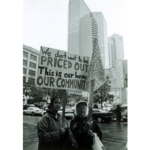 Two women hold protest signs in Chinatown