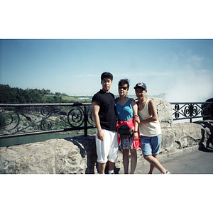Young men and a woman stand near a wall overlooking Niagara Falls