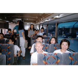 Chinese Progressive Association members sit and converse on a charter bus
