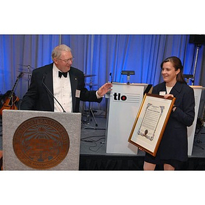 Chairman Emeritus of the Board of Trustees Neal Finnegan, left, presenting a certificate to Sophia and Bernard Gordon at a dinner honoring Huntington Society members