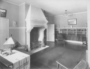 Interior view of living room, looking toward bookshelves, location unknown, undated