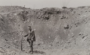 Soldier standing in large shell hole