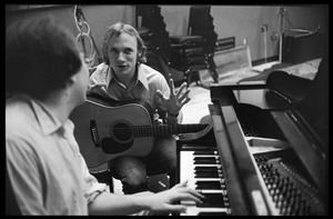 Stephen Stills with his guitar talking with Michael Sahl on piano at Wally Heider Studio 3 during production of the first Crosby, Stills, and Nash album