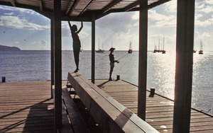 Boys swing and fish from a pier