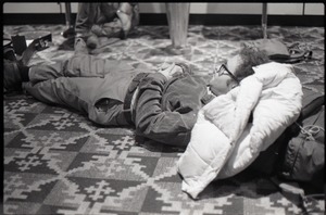 Person lying on the floor while waiting at JFK airport