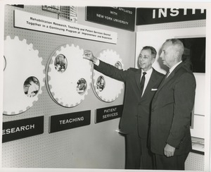 Two unidentified men in front of an ICD exhibit