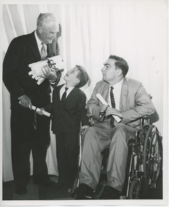 Bruce Barton handing diplomas to young clients at graduation exercises