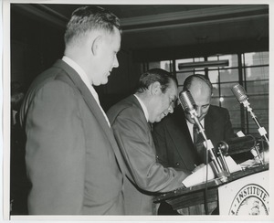 Willis C. Gorthy with unidentified speaker and staff on stage at Institute Day