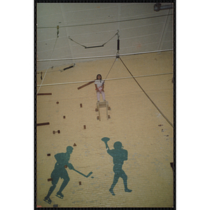 A girl stands on a platform in a gymnasium