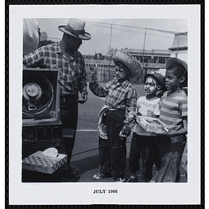 A man talks to three boys on a playground during Tom Sawyer Day