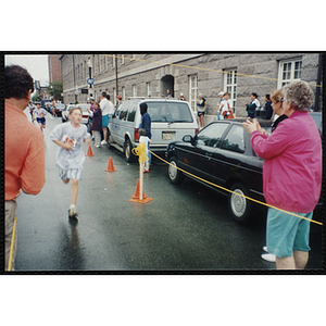 A boy runs past spectators during the Battle of Bunker Hill Road Race