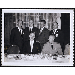Tip O'Neill, at left, seated with an unidentified man while four others stand behind them at the Kiwanis Club's Bunker Hill Postage Stamp Luncheon