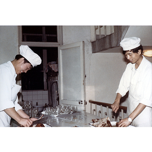 Two men prepare food in a restaurant kitchen
