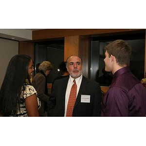 Anthony Manganaro speaks with two students at the Torch Scholars dinner