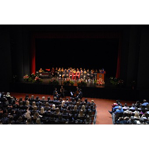 School of Nursing faculty seated onstage during convocation as students and audience look on